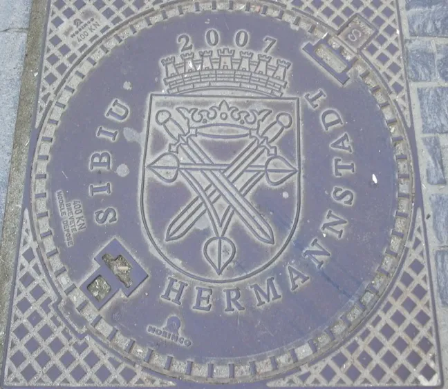 Rumänien, Hermannstadt_zweisprachiger_Kanaldeckel, 2007, Wolfgang J. Kraus, CC BY-Sa 3.0.JPG