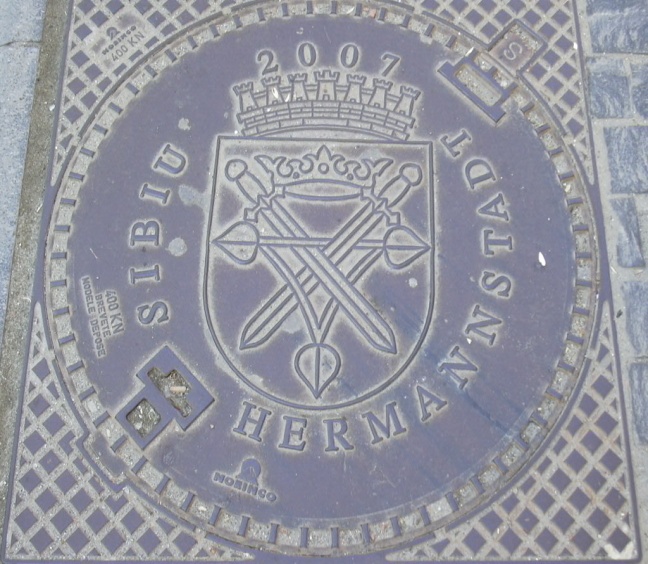 Rumänien, Hermannstadt_zweisprachiger_Kanaldeckel, 2007, Wolfgang J. Kraus, CC BY-Sa 3.0.JPG